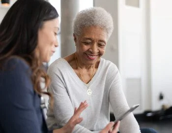 Older woman with team member looking at her phone Older woman with team member looking at her phone
