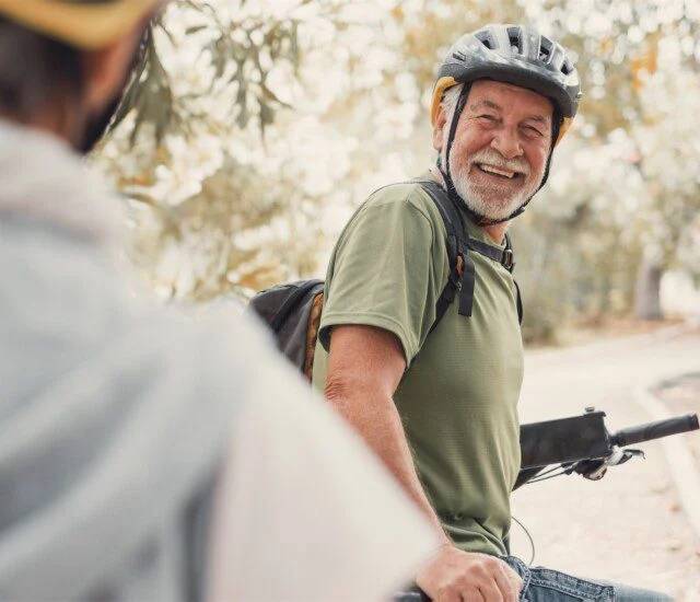 Man on bike wearing helmet and smiling