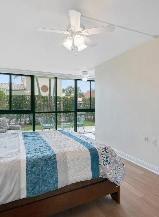 Modern bedroom in a senior living apartment with large windows and natural light