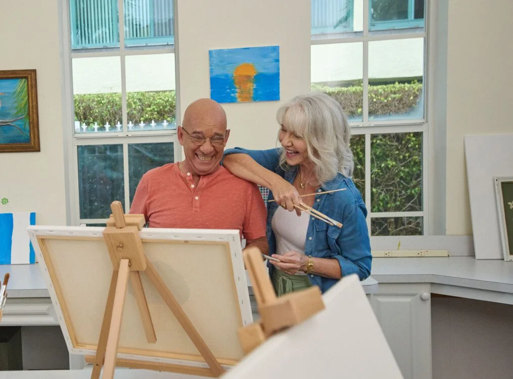 Senior man and senior women smiling at a canvas painting