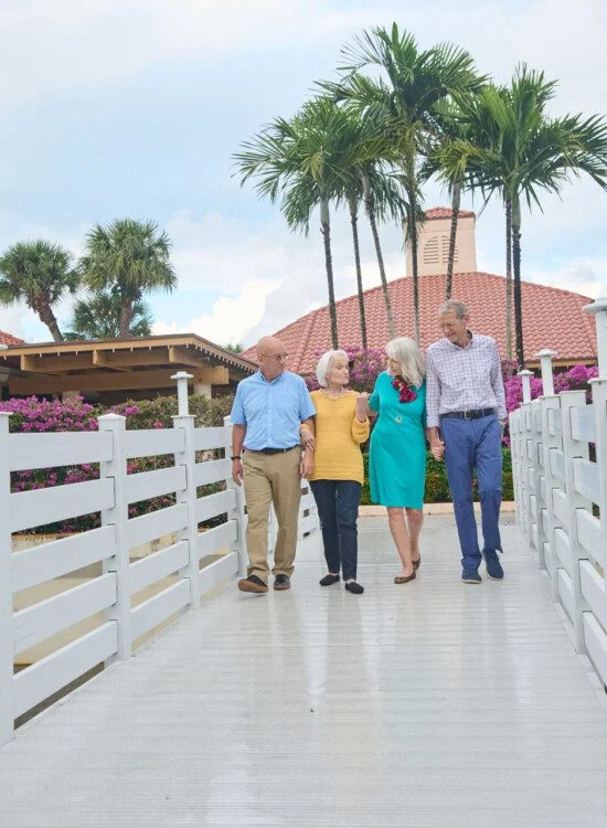 A group of seniors walking down a bridge holding hands