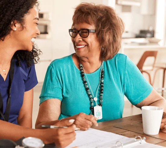 A senior woman smiling and talking to her waterford caretaker
