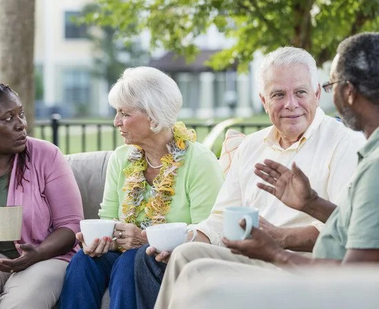A group of seniors talking while drinking coffee