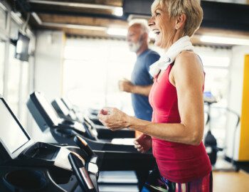 Mature people running in machine treadmill at fitness gym club