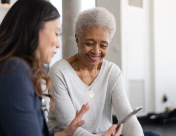 Older woman with team member looking at her phone Older woman with team member looking at her phone