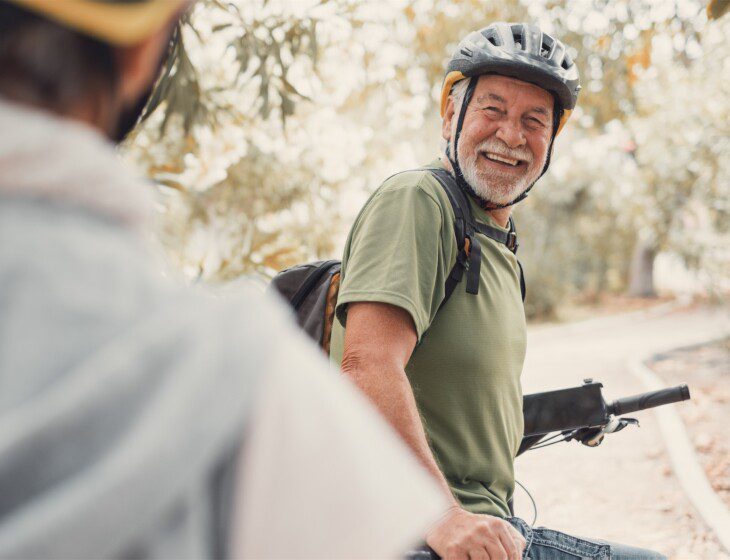 Man on bike wearing helmet and smiling