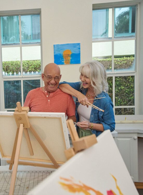 Senior man and senior women smiling at a canvas painting