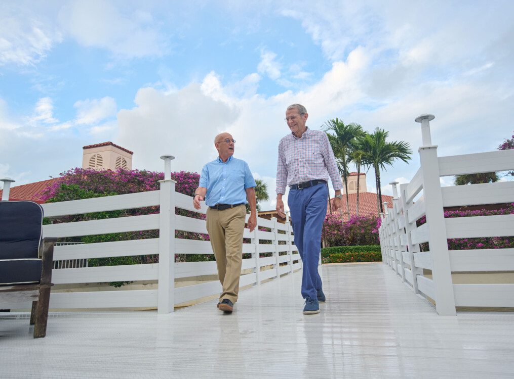 Twos senior men walking across a bridge