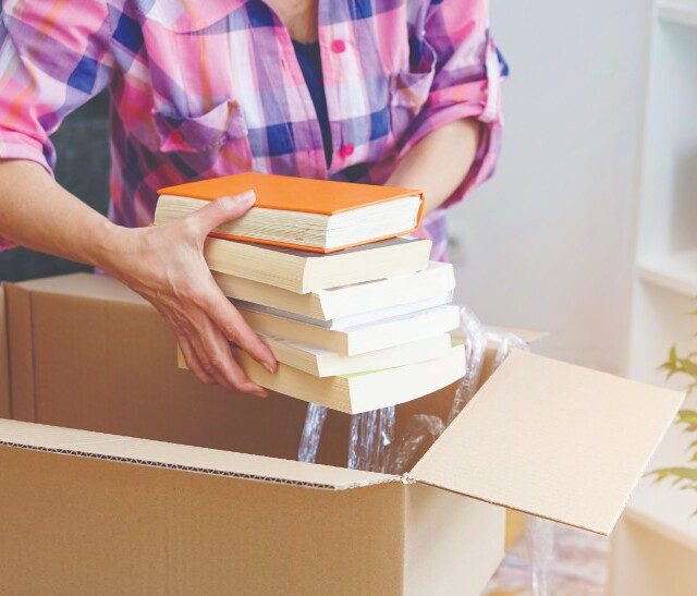 A woman packing books into a box