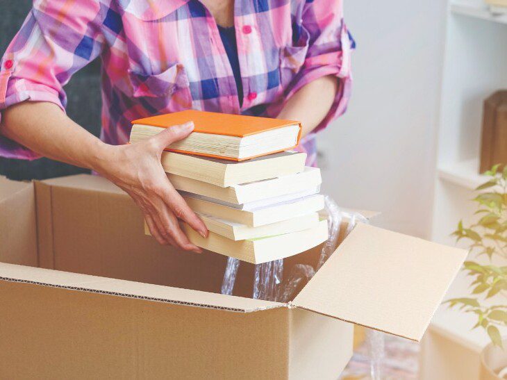 A woman packing books into a box