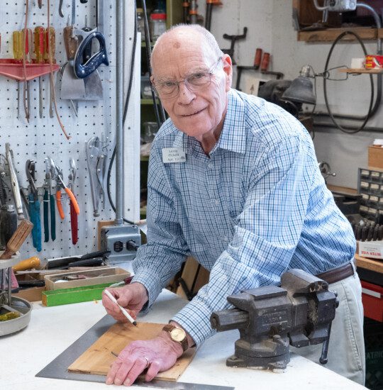 A senior man looking up from wood working