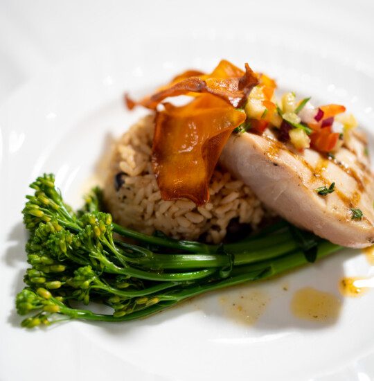 And elegant dinner of greens, rice, and meat on a plate