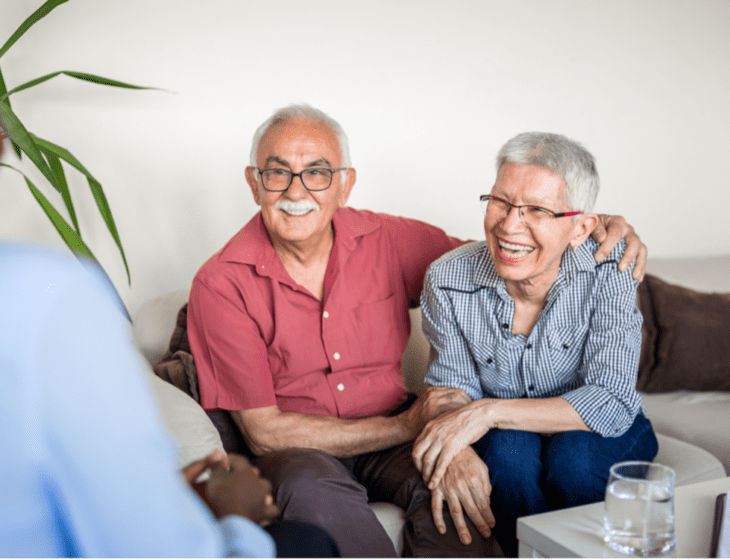 A senior couple talking to someone while on a couch