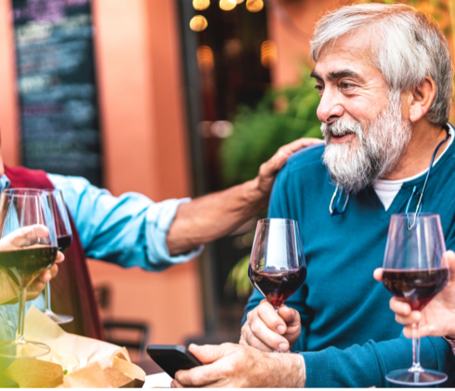 A group of seniors drinking wine and laughing