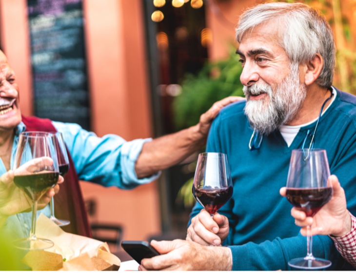 A group of seniors drinking wine and laughing