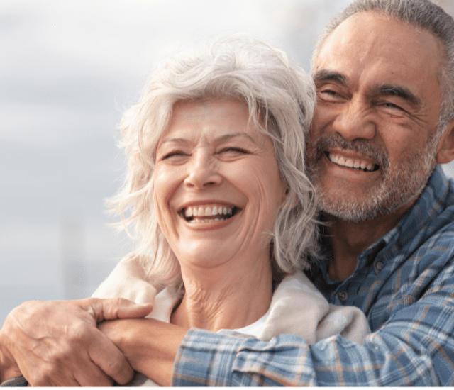 A senior couple hugging facing the same direction