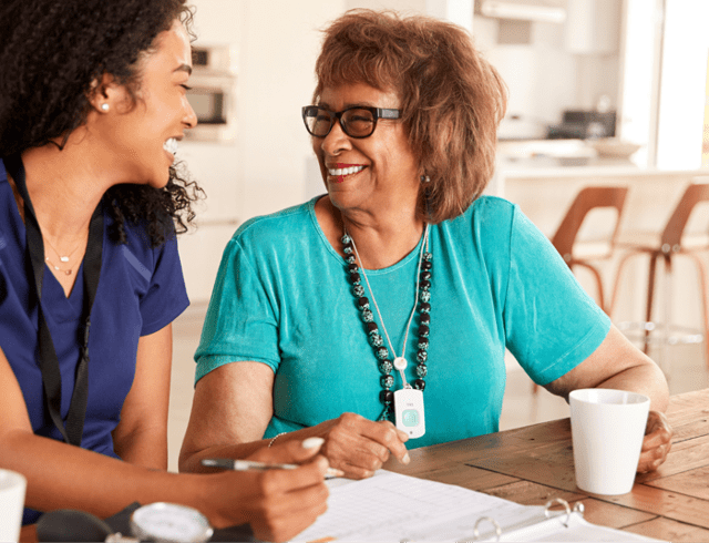 A senior woman smiling and talking to her waterford caretaker