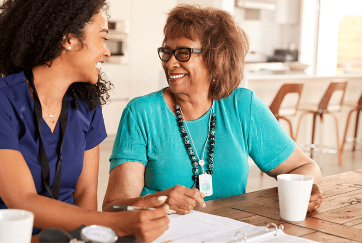 A senior woman smiling and talking to her waterford caretaker