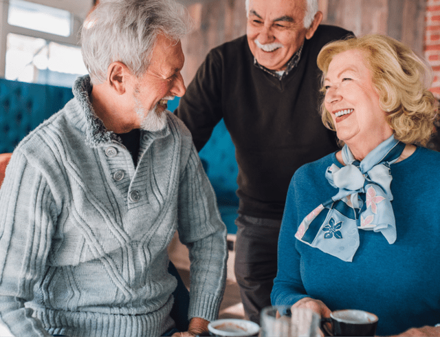 A group of seniors laughing together over lunch