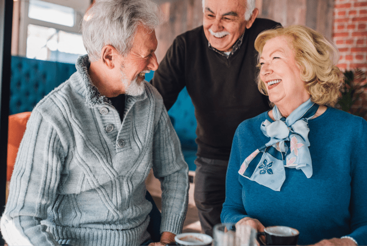 A group of seniors laughing together over lunch