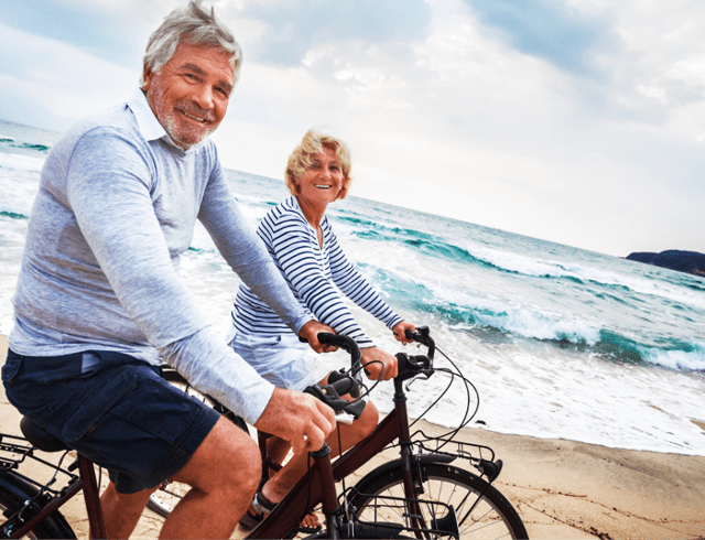 A senior couple on a bike ride on the beach