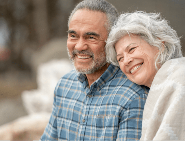 A senior couple sitting close to each other