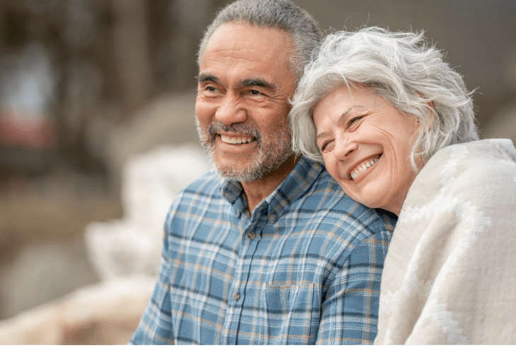 A senior couple sitting close to each other