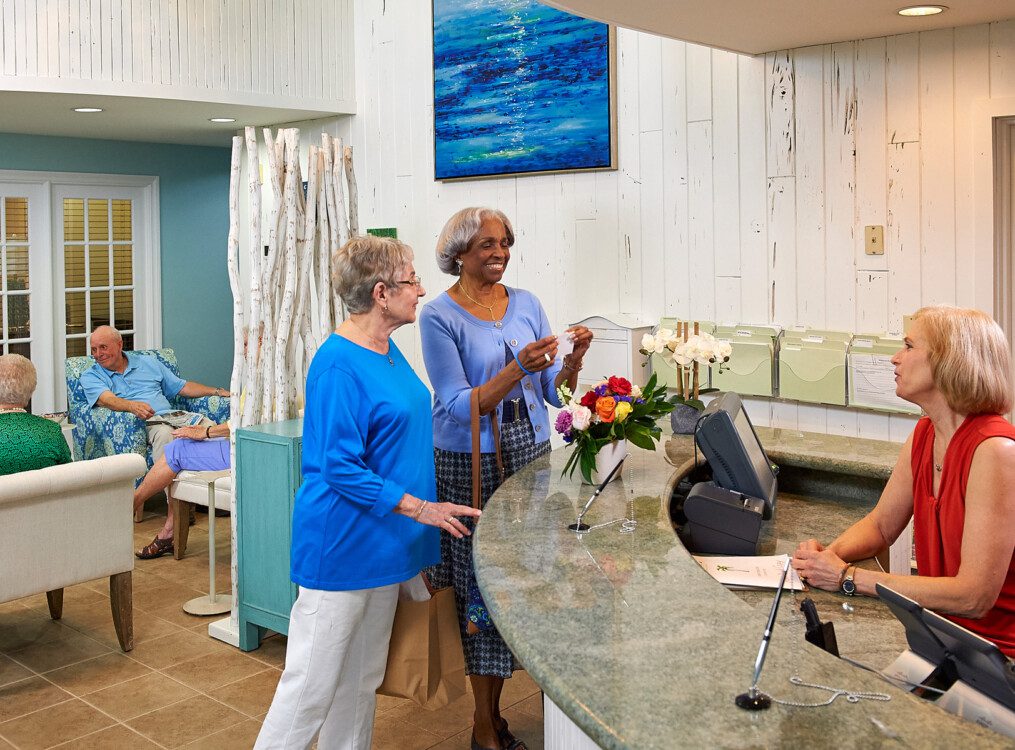 Two senior woman talking to reception