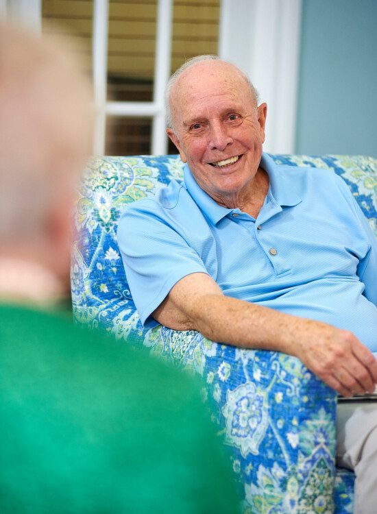 A senior man smiling while talking to a senior woman