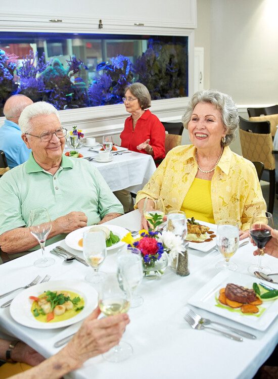 A group of senior eating dinner together and smiling