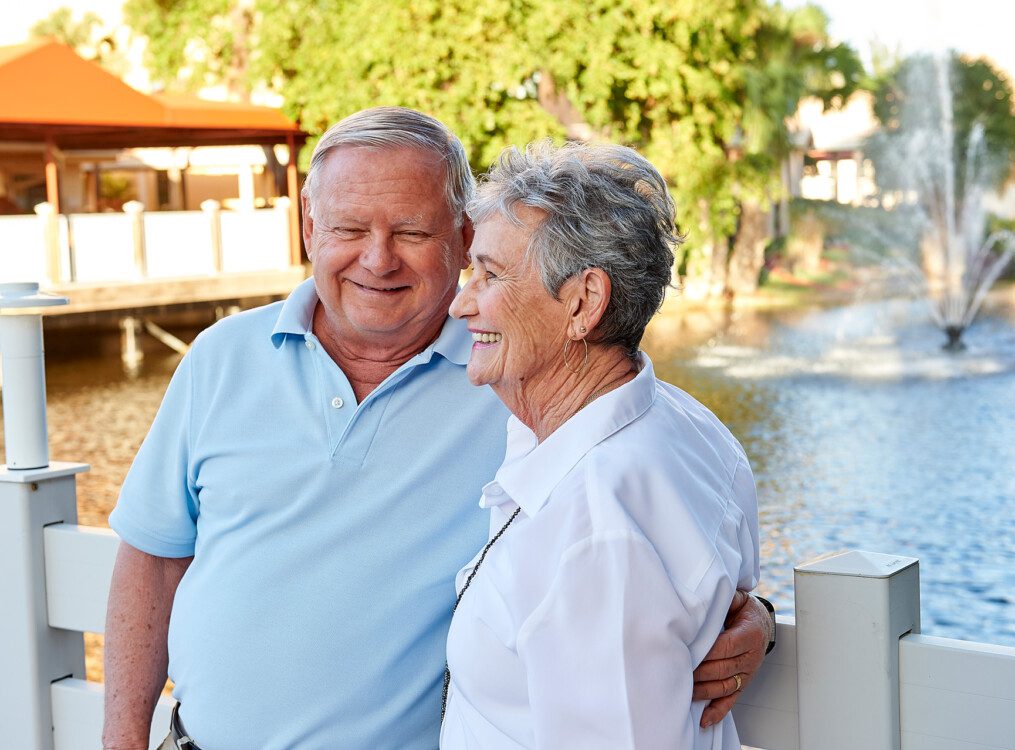 A senior couple standing on a bridge