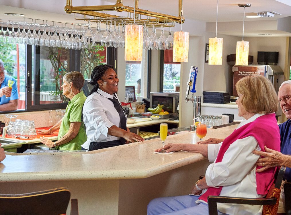 A bartender talking to two seniors