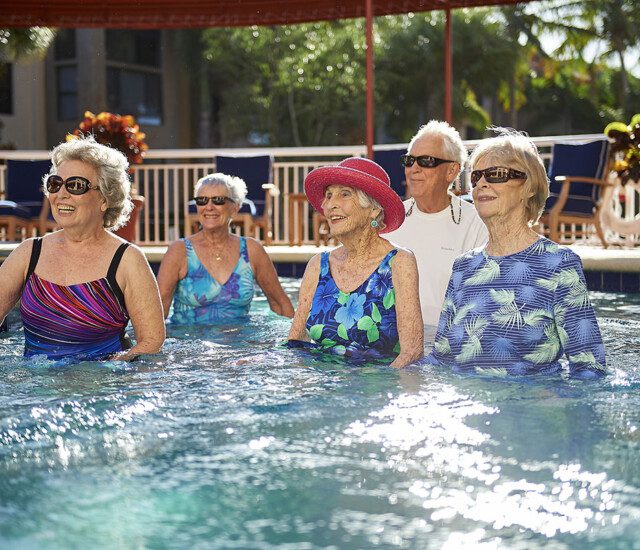 Group of seniors standing in a pool smiling