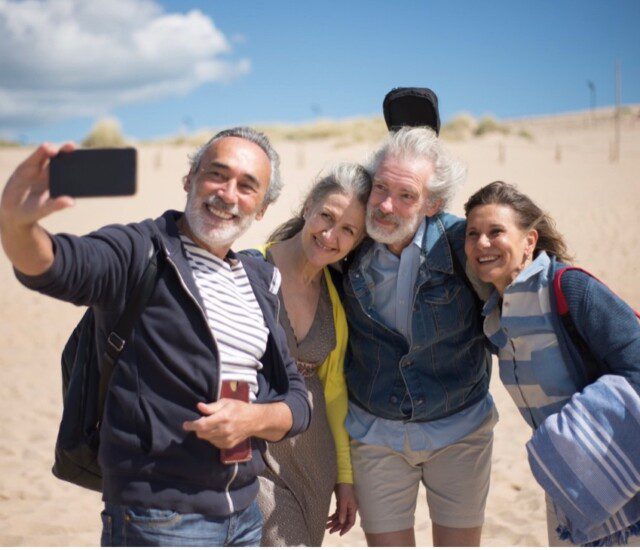 Four seniors taking a selfie on the beach