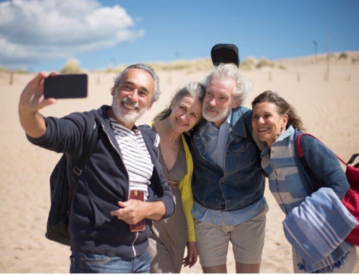 Four seniors taking a selfie on the beach