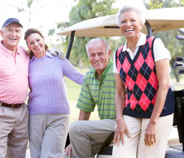 A group of seniors standing next to a golf cart