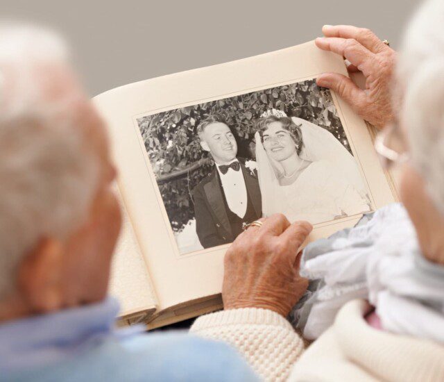 A senior couple looking at their wedding photos