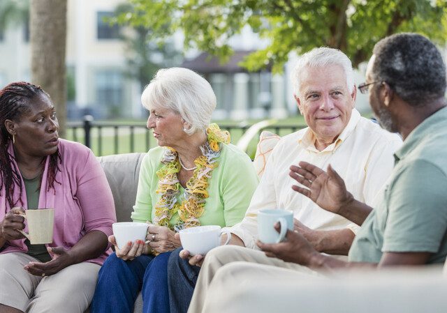 A group of seniors talking while drinking coffee