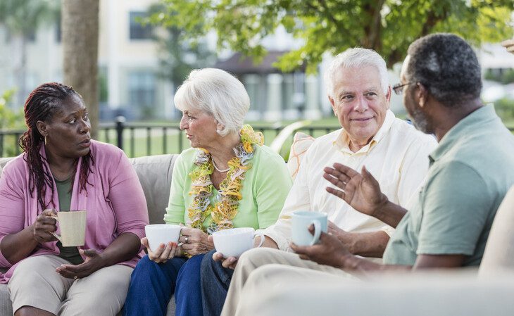 A group of seniors talking while drinking coffee