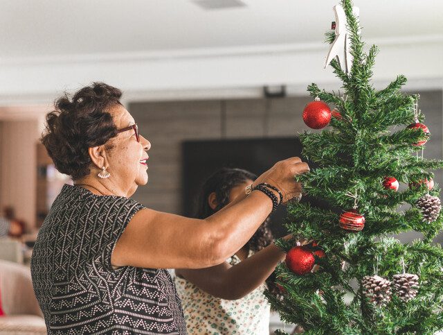 A senior women decorating a tree for the holidays