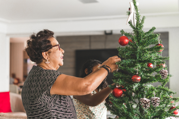 A senior women decorating a tree for the holidays