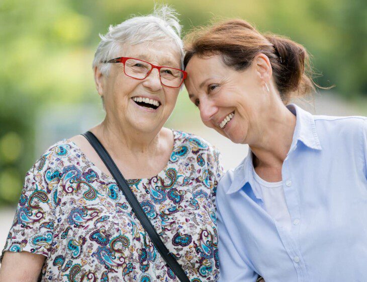 Two senior women smiling while outside