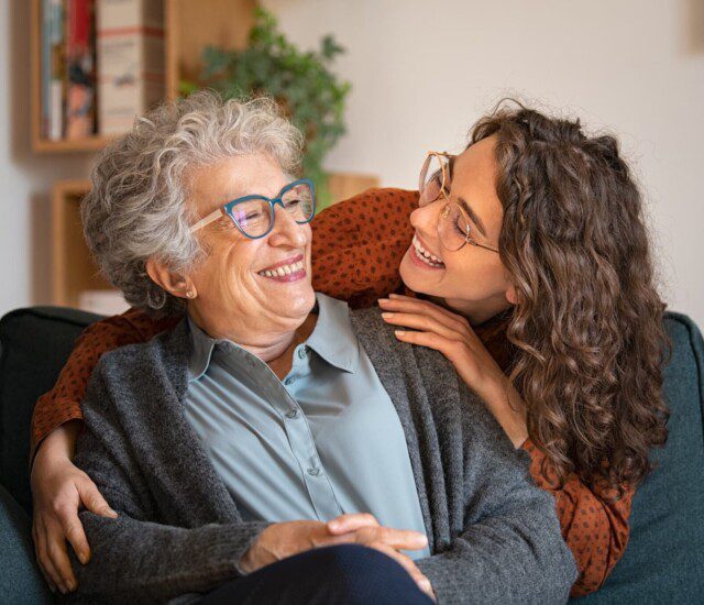 A senior woman laughing with a younger women