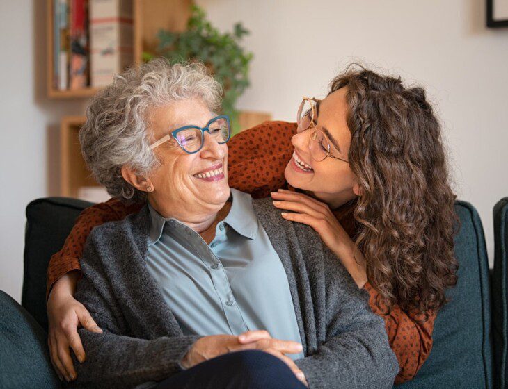 A senior woman laughing with a younger women