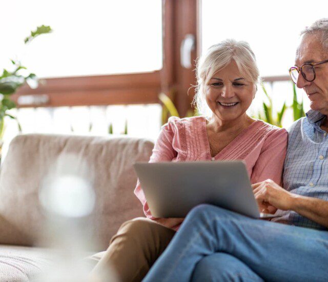 A senior couple looking at a laptop together